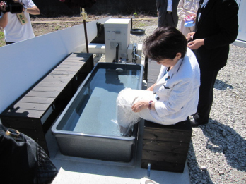 崎山港で、水素を燃料として作った足湯を体験する山谷大臣の画像