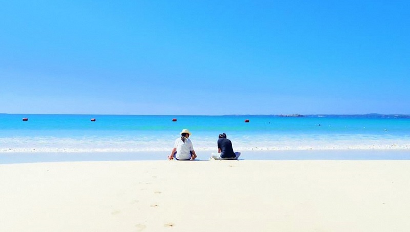 海を眺める二人の写真