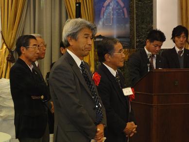 東京五島会総会で起立して話を聞く野口市長の様子。