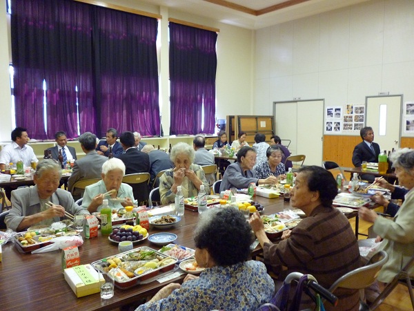 敬老会で楽しく食事をする高齢者たちの様子。