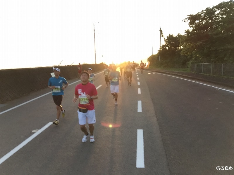 夕陽を背に走る選手たちの様子。