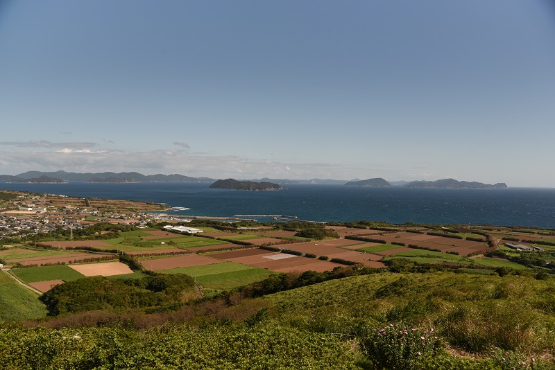 箕岳展望所から田園地帯と青い海を見下ろした風景。海の向こうには島々が点在している。