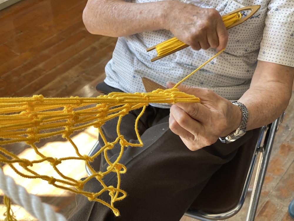 網を編む人の手のアップ
